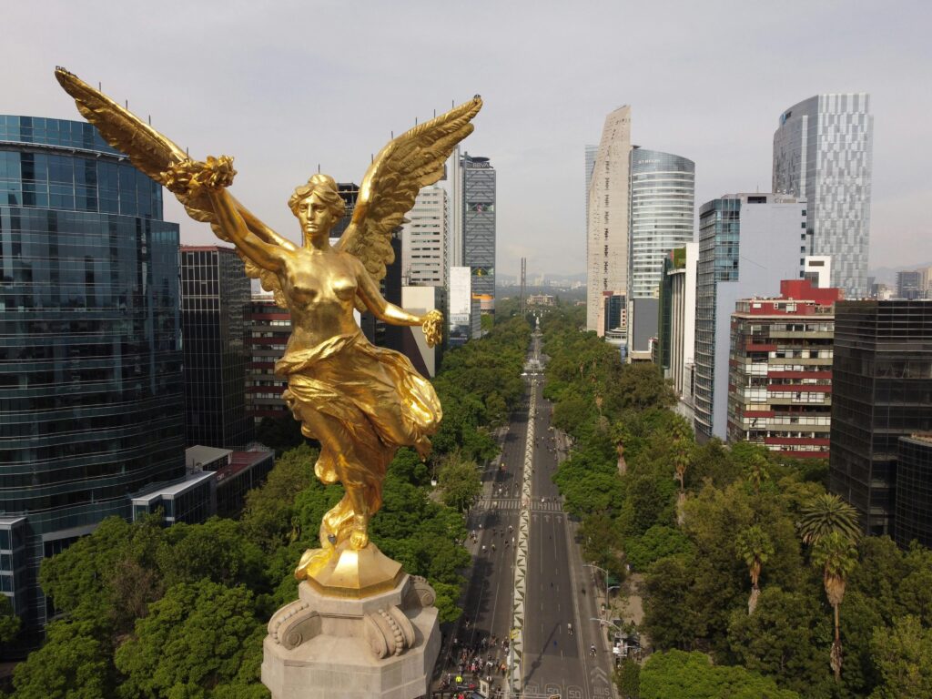 Aerial shot featuring the iconic Angel of Independence in Mexico City's vibrant urban landscape.
