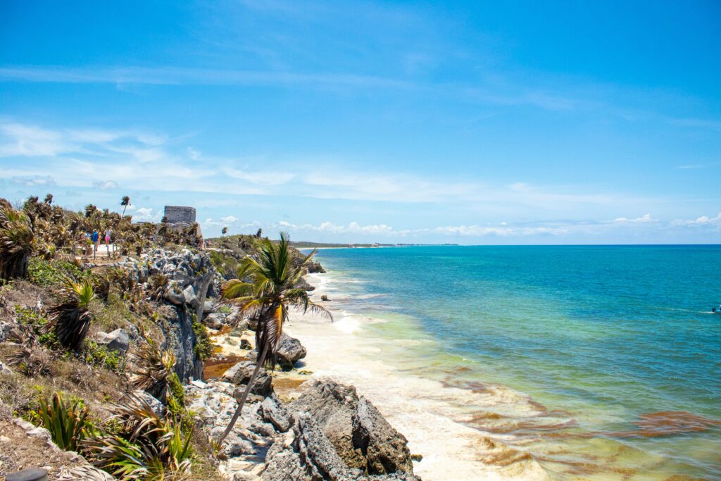 Qué hacer en Tulum sin gastar una fortuna (guía real) Stunning beach view at Tulum, Mexico featuring turquoise waters and ancient ruins.